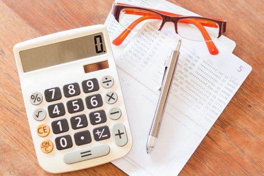 Top view of calculator, pen, eyeglasses and bank account passbook, stock photo