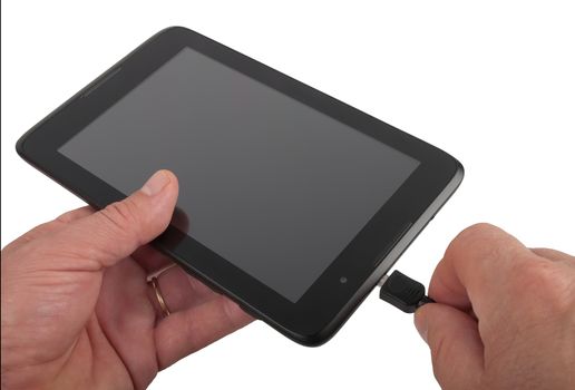 man charging black tablet, studio shot