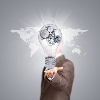 World map. Businessman in a suit hold bulb with metal gears