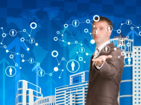Skyscrapers with world map and arrows. Businessman in a suit hold network