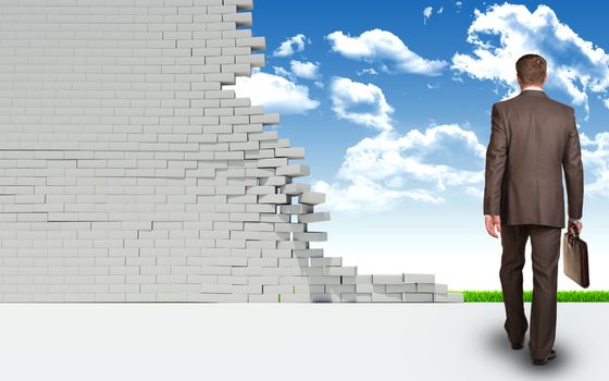 Businessman with briefcase goes through ruined brick wall. Green landscape as backdrop