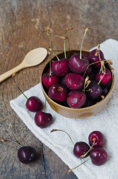 fresh cherries in bowl ,  on wooden table  background