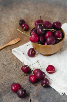 fresh cherries in brown bowl with wooden fork