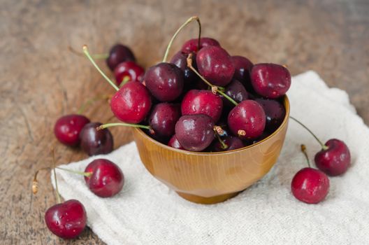 close up of fresh cherries  in brown bowl