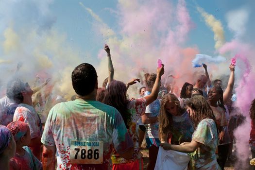 Lawrenceville, GA, USA - May 31, 2014:  People throw packets of colored corn starch in the air to get covered in color at Bubble Palooza.