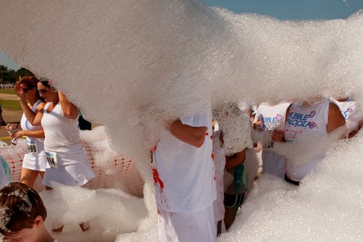 Lawrenceville, GA, USA - May 31, 2014:  People walk through a huge cloud of bubbles and foam at Bubble Palooza.