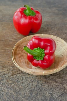 red bell peppers in basket on wooden table 