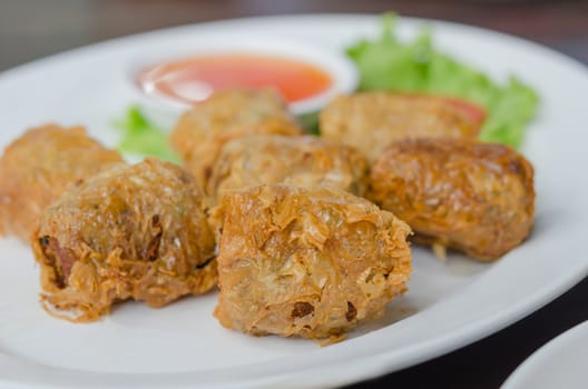 close up deep fried crab meat roll cake on white dish , chinese food