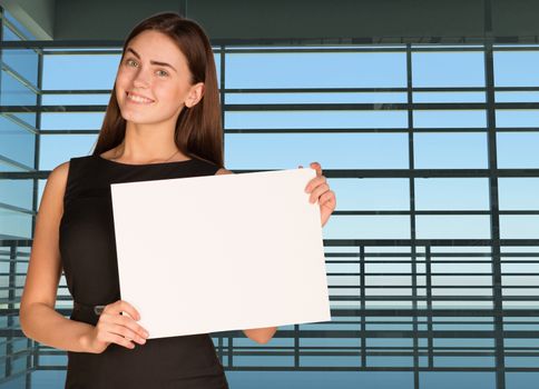 Businesswoman holding paper sheet. Large window as backdrop