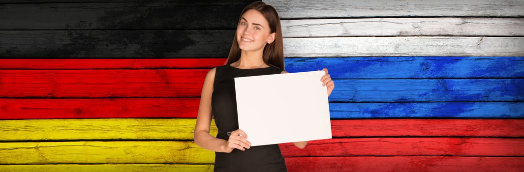 Businesswoman holding paper sheet. Germany and Russian flags as backdrop