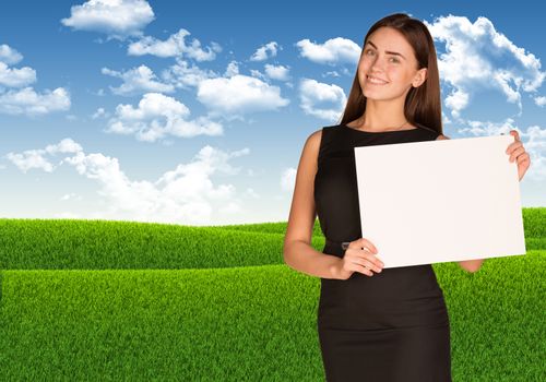 Businesswoman holding paper sheet. Blue sky and green grass as backdrop