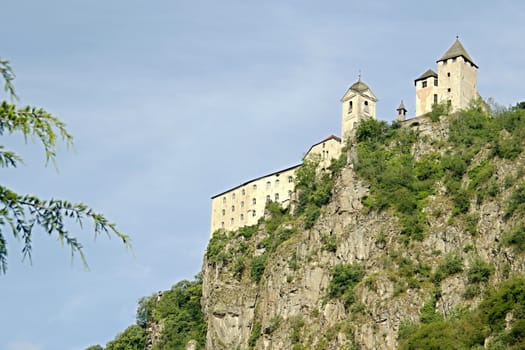 Photo shows an old Italian castle on the mountains.
