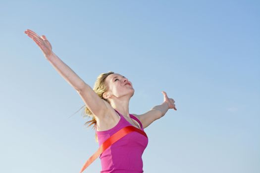 young blond woman  crossing finishing line
