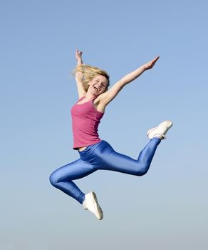 joyful young blond woman leaping