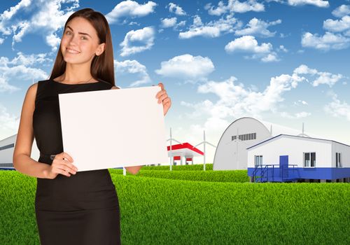 Businesswoman hold white paper. Blue sky, green grass and industrial area as backdrop