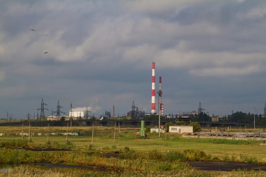 Green landscape with factories on the horizon