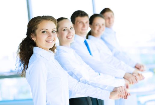 young business people holding hands, standing in a row, the concept of teamwork