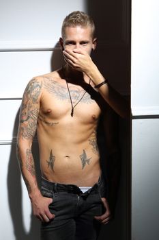 Handsome tattooed man with no shirt touched by the woman's hand