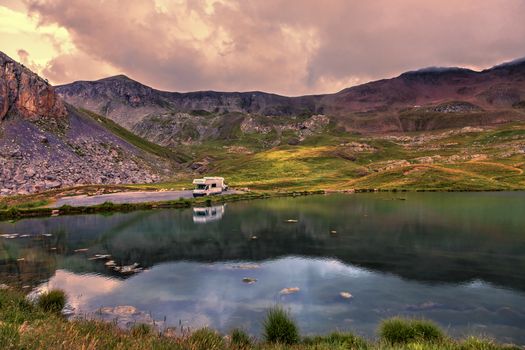 Colorful sunset over the Lake Essaupres located at 2306 m altitude near one of the highest asphalted road in Europe which lead to Col de la Bonette (2715 m) in Alpes-de-Haute-Provence, south of France.