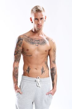 Young attractive tattooed man on a white background