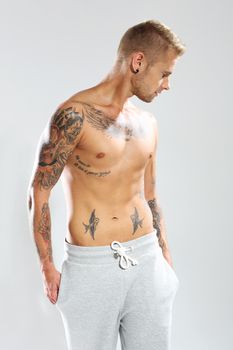 Young attractive tattooed man on a white background