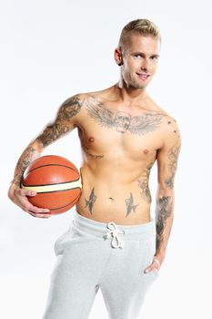 Attractive young boy with an orange ball for basketball, tattooed in