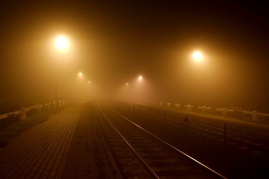 Rails in the fog at night