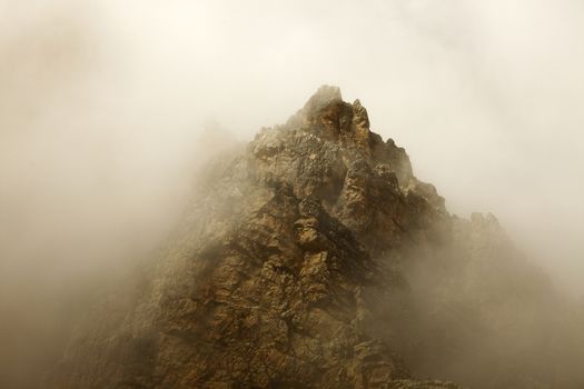 High mountain ridge in thick fog