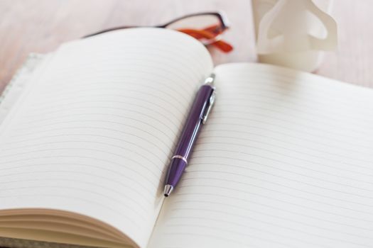 Pen and notebook on wooden table, stock photo