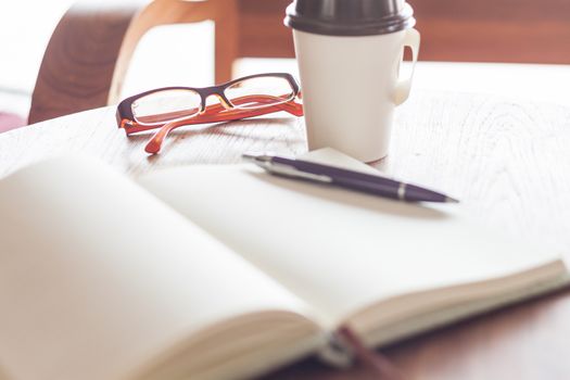 Eyeglasses with coffee cup in coffee shop, stock photo