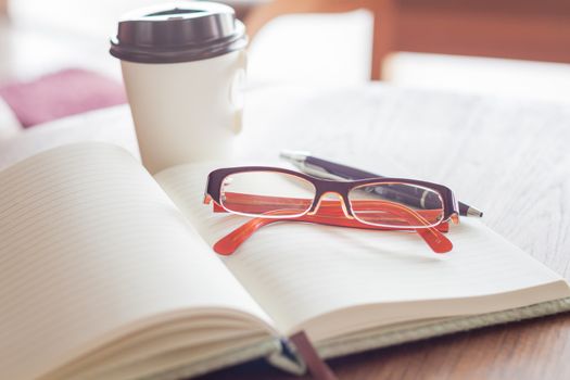 Eyeglasses with pen and coffee cup, stock photo