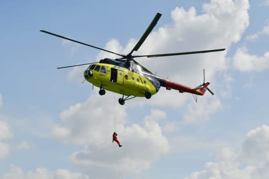 The yellow MI-8 helicopter hanged with an open door. Landing of troops