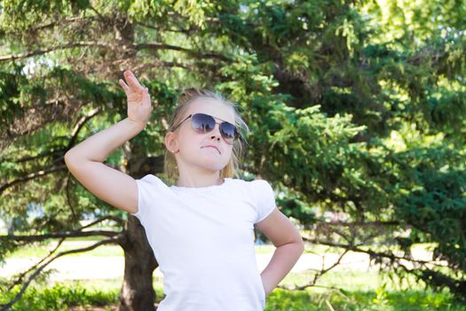 Cute girl playing with sunglasses in summer