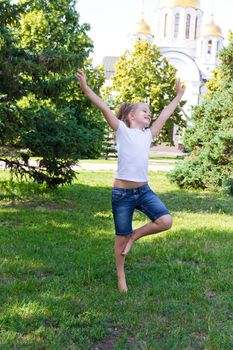 Cute girl with blond hair jumping on one leg