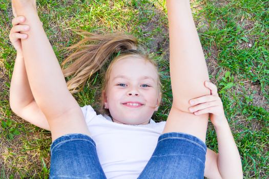 Cute girl playing legs upwards in summer