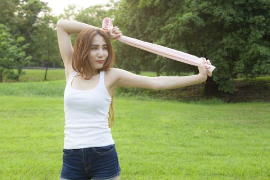 Woman warming up before exercise. on grass Within the park in the evening