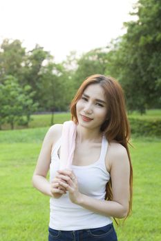 Woman standing rest after jogging. On lawn in the park