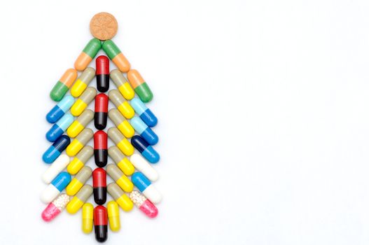 Christmas tree made of capsules on white background