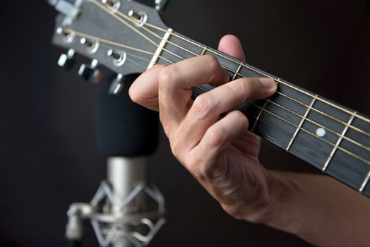 Close-up of the fingering for a C7 sustained chord on a left handed classical guitar.