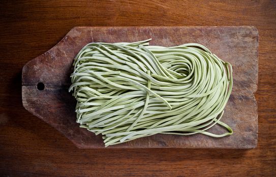 green pasta on wooden table