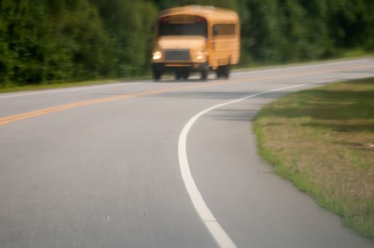 blurry abstract view of school bus driving on road