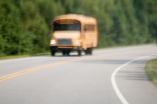 blurry abstract view of school bus driving on road