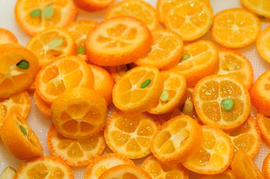 tray full of ripe kumquat slices, suitable as background