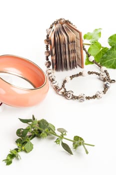 vintage necklace and bracelet with green leafs and a little book