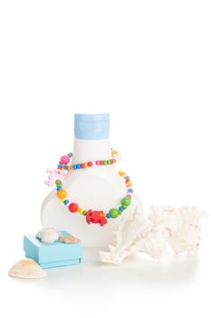 white lotion bottle with color necklace and seashells