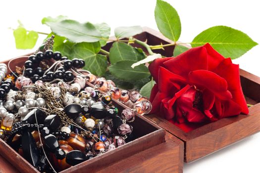 bunch of different color woman jewelry in wooden box and rose