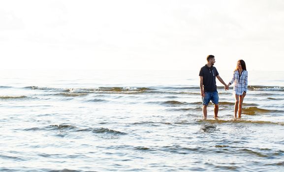 Summer, love. Attractive couple walking on the beach