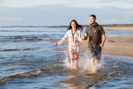 Summer, love. Attractive couple running on the beach