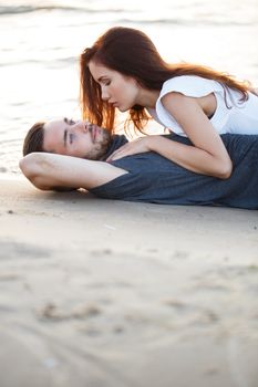 Summer, love. Attractive couple lying on the beach
