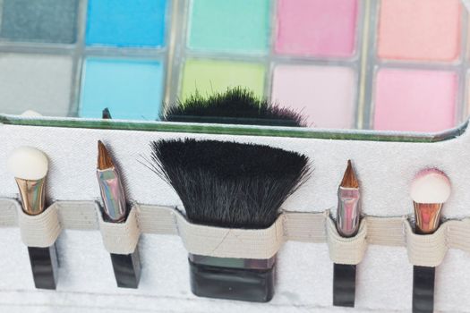 Multicolored eye shadows with cosmetics brush. Eyeshadow makeup palette. Colorful eye shadow make up.